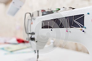 Sewing machine with colorful needles at workshop