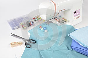 Sewing machine and colorful thread rolls, scissors, fabric and a