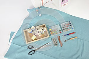 Sewing machine and colorful thread rolls, scissors, fabric and a