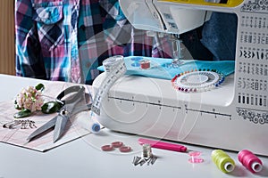 Sewing Machine With Different Accessories On White Table.