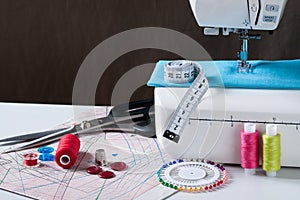 Sewing Machine With Different Accessories On White Table.