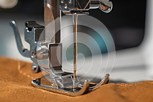 Sewing machine foot in close up. Selective focus on the tip of the needle