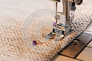 Sewing machine foot on material with threaded needle ready to sew.