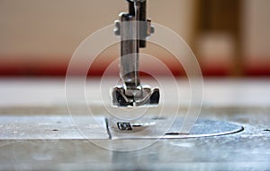 Sewing machine foot and needle. Close up, macro. Empty space for text. Craft fabric industrial