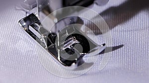 Sewing machine makes a stitch of black thread. Slow motion