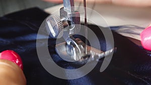 Sewing machine needle in motion. Close-up macro of sewing machine needle moves up and down and tailor sews