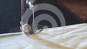 Sewing Machine Needle in Motion. Close-up of sewing machine needle rapidly moves up and down. The tailor sews fabric on