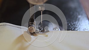 Sewing Machine Needle in Motion. Close-up of sewing machine needle rapidly moves up and down. The tailor sews fabric on