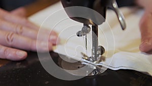 Sewing Machine Needle in Motion. Close-up of sewing machine needle rapidly moves up and down. The tailor sews fabric on