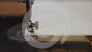 Sewing Machine Needle in Motion. Close-up of sewing machine needle rapidly moves up and down. The tailor sews fabric on