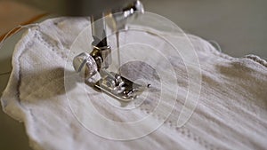 Sewing Machine Needle in Slow Motion. A Tailor Sews Homemade Face Mask of Fabric