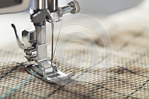 Sewing machine with needle, thread and fabric. Item of clothing. Sewing industry