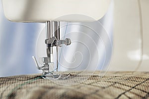 Sewing machine with needle, thread and fabric. Item of clothing. Sewing industry