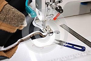 Sewing machine and other tools on white table in professional workshop, closeup
