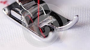 Sewing machine performs original stitch thin red thread. Slow motion