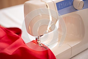 Sewing machine with red cloth closeup. sewing process in the re-stitching phase