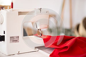 Sewing machine with red cloth closeup. sewing process in the re-stitching phase