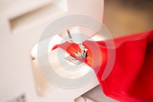 Sewing machine with red cloth closeup. sewing process in the re-stitching phase