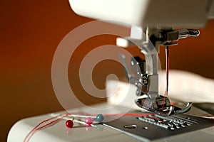 Sewing machine. Red thread in the needle of the sewing machine.