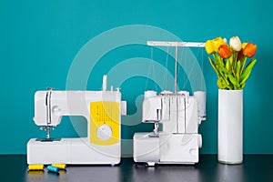 Sewing machine and serger on table in workshop.