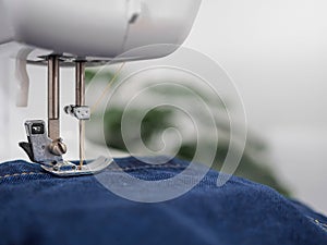 sewing machine sew seam of blue denim jean