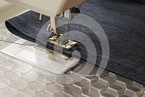 Sewing machine sews denim fabric