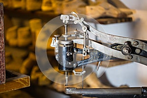 Sewing machine in a shoe workshop, shoe lasts in the background