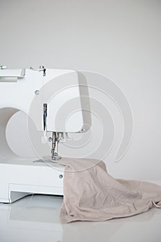 Sewing machine on table in tailor`s workshop