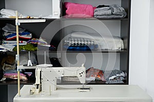 Sewing machine on table in workshop, tailor atelier