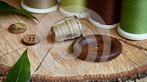 Sewing Needles with Thimble and Buttons Surrounded by Spools of Thread