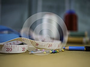 Sewing notions, a tape measure, pins and a dressmaker pencil. photo