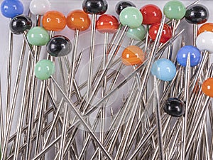 sewing pins with multi-colored round heads on a light background