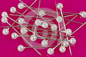Sewing pins on a pink background.