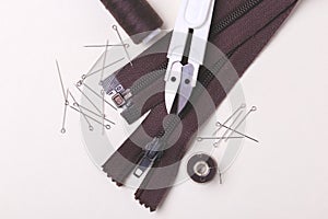 Sewing pins, scissors, zipper and plastic bobbin with colour threads