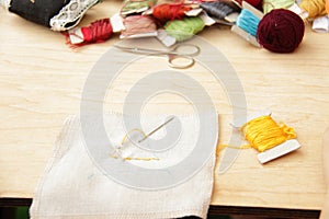 Sewing set: fabrics and threads on wooden table