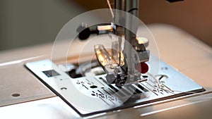 Sewing on a sewing machine. Close up of women`s hands seamstresses adjust the fabric and sew on a sewing machine