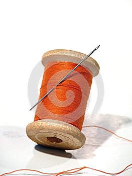Sewing spool with a needle. A sewing needle.