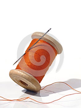 Sewing spool with a needle. A sewing needle.