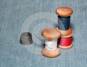 Sewing spools with colorful threads and needles, metal thimble l