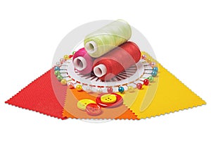 Sewing  thread, needle, bobbins, buttons and fabric samples red, yellow  color on isolated white  background