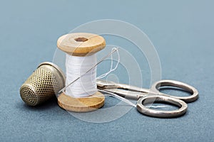 Sewing thread, needle, thimble and scissors