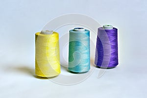 Sewing thread rolls in different colors on white background