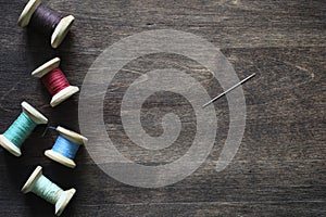 Sewing thread on a wooden background. Set of threads on bobbins