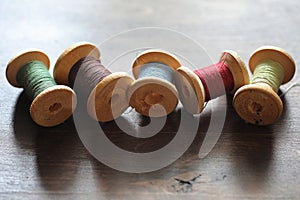 Sewing thread on a wooden background. Set of threads on bobbins