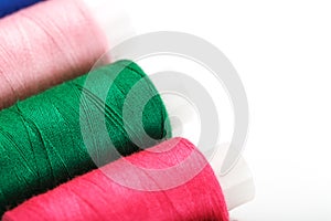 Sewing threads of different colors on reels on a white background. Free space, close-up. Isolate