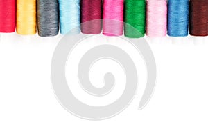 Sewing threads of different colors on reels on a white background. Free space, close-up. Isolate