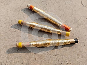 Sewing threads golden color closeup, hand loom shuttle spindle, other name zari, jari, taar, golden silk, silver silk