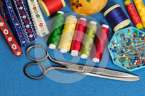 Sewing tools and accessories of tailor on blue background.