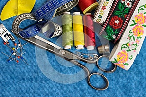 Sewing tools and accessories of tailor on blue background.