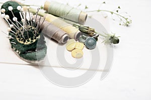Sewing tools with dandelion flowers on vintage background